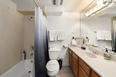 a bathroom with a toilet and a tub and a sink at The Italian Retreat, Little Italy in San Diego