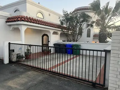 a black fence in front of a white house at Oceanfront 2BR Condo, Private Beach & Patio, Rare Find in Carlsbad