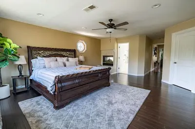 a bedroom with a bed and a ceiling fan at Resort style back yard heated pool and spa in Encinitas