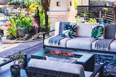 a patio with a couch and a fire pit at Resort style back yard heated pool and spa in Encinitas