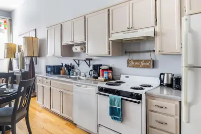 a kitchen with white cabinets and a white stove top oven at Free Parking Loft Suite Walk to Conv Center in San Diego