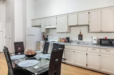 a kitchen with a dining table and white cabinets at 2BR Free Parking Walk to Convention Center in San Diego