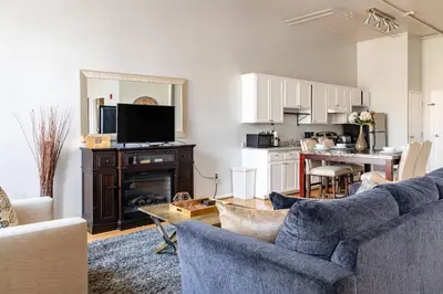 a living room with a blue couch and a kitchen at Loft Suite Walk to Conv Center Free Parking in San Diego