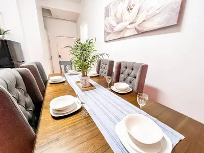 a dining room table with white plates and chairs at Walk to Conv Center 2BR Top Floor Parking Incl in San Diego