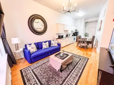a living room with a blue couch and a table at Walk to Conv Center 2BR Top Floor Parking Incl in San Diego