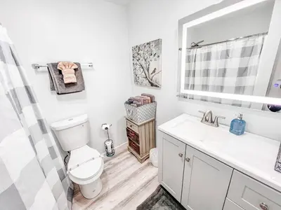 a bathroom with a toilet and a sink and a mirror at Walk to Conv Center 2BR Top Floor Parking Incl in San Diego