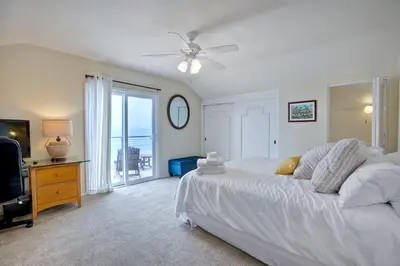 a bedroom with a white bed and a television at Oceanfront 4BR, Private Beach & Patio, Remodeled Kitchen in Oceanside