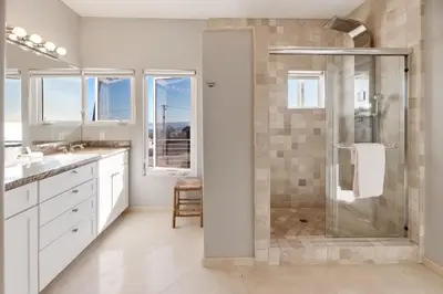 a white bathroom with a shower and a sink at California Dreamin Your Ocean-View Sanctuary in San Diego