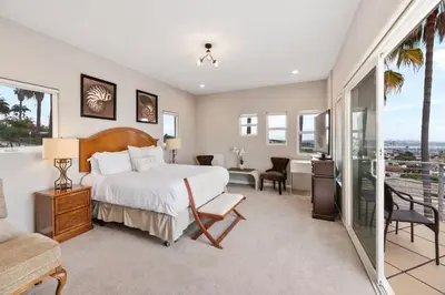 a bedroom with a large bed and a balcony at California Dreamin Your Ocean-View Sanctuary in San Diego