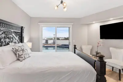 a white bedroom with a bed and a window at California Dreamin Your Ocean-View Sanctuary in San Diego