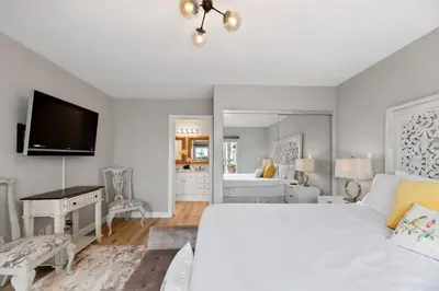 a white bedroom with a bed and a mirror at California Dreamin Your Ocean-View Sanctuary in San Diego