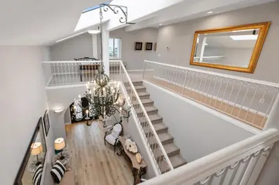 a staircase with a mirror and a chandelier at California Dreamin Your Ocean-View Sanctuary in San Diego
