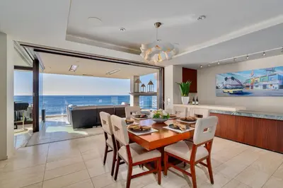a kitchen and dining room with a table and chairs at Luxury Beachfront Home with Hot Tub & Ocean Views in San Diego
