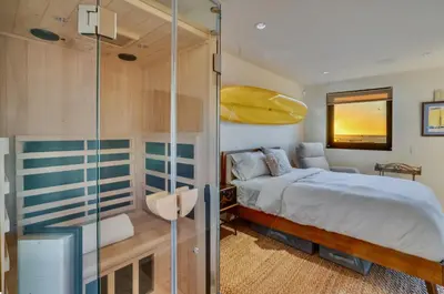 a bedroom with a bed and a yellow canoe on the wall at Luxury Beachfront Home with Hot Tub & Ocean Views in San Diego