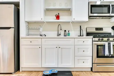 a kitchen with white cabinets and a stainless steel refrigerator at Pet-Friendly San Diego Studio about 14 Mi to Downtown in San Diego