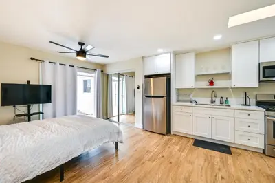 a kitchen with white cabinets and a bed in a room at Pet-Friendly San Diego Studio about 14 Mi to Downtown in San Diego