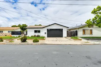 a white house with a garage on a street at Pet-Friendly San Diego Studio about 14 Mi to Downtown in San Diego