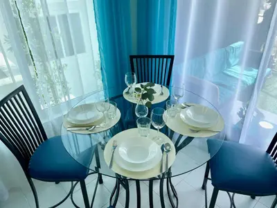a glass table with chairs and wine glasses at SurfView VR - Best Ocean and Pier View, 5 mins to Beach, Cozy Patio, Pet Friendly in San Clemente