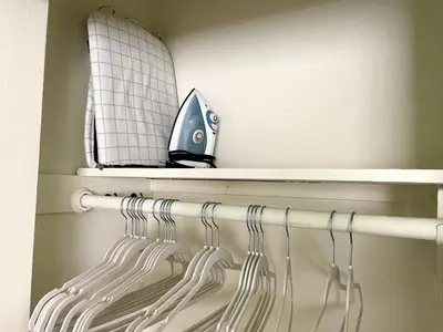 a closet with a rack of white hangers at SurfView VR - Best Ocean and Pier View, 5 mins to Beach, Cozy Patio, Pet Friendly in San Clemente