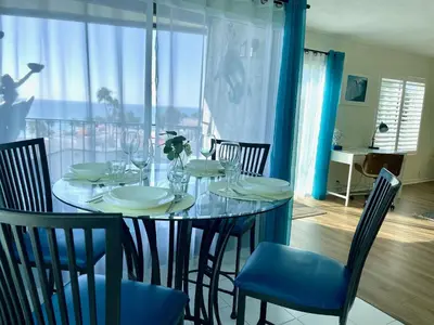 a dining room with a table with chairs and a window at SurfView VR - Best Ocean and Pier View, 5 mins to Beach, Cozy Patio, Pet Friendly in San Clemente