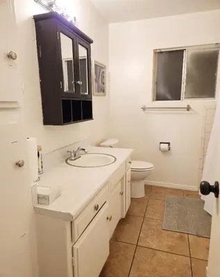 a bathroom with a sink and a toilet at Centrally Located, 4x Queen, 300 MBPS Internet with Backyard! in Hemet