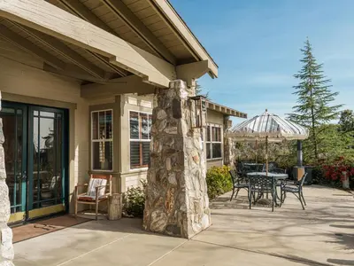 a patio with a table and umbrella on a house at Orchard Hill in Julian