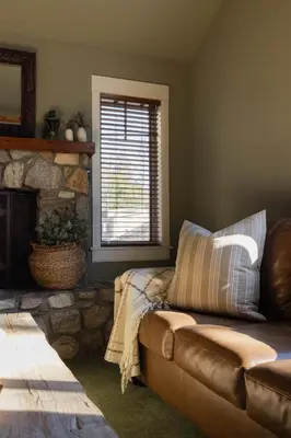 a living room with a couch and a stone fireplace at Orchard Hill in Julian