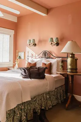 a bedroom with a large bed with orange walls at Orchard Hill in Julian