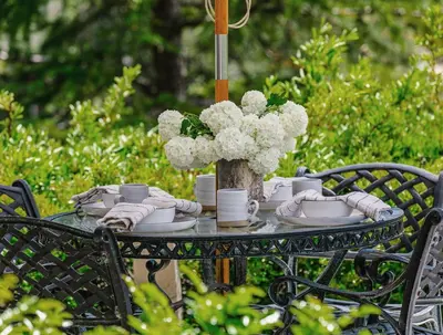 a table with a centerpiece of white flowers and cups at Orchard Hill in Julian