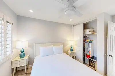a white bedroom with a bed and two night stands at Pacific Sunset San Miguel 16 in Oceanside