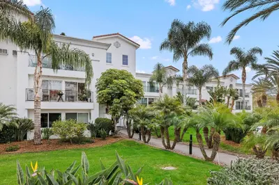 a building with palm trees in front of it at 604 Gorgeous Renovated Condo, Steps to Omni Spa, Golf, Tennis, PFC & Exclusive Building Pool in Encinitas