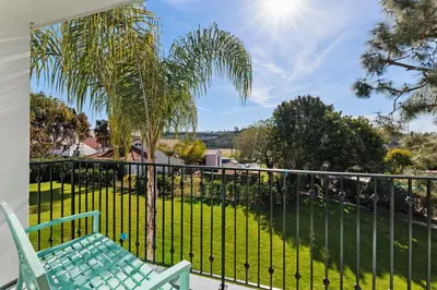 a balcony with a chair and a palm tree at 628 Escape to Relaxation-Free Wifi-Free Parking in Encinitas