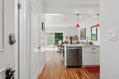 a kitchen with white walls and wooden floors and a table at 628 Escape to Relaxation-Free Wifi-Free Parking in Encinitas