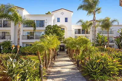 a white building with palm trees in front of it at 629 Walk to Restaurants Close to Golf and Spa Luxury Inside the gates in Encinitas