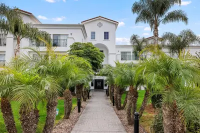 a white building with palm trees in front of it at 644 A Renovated Condo at a World-Renowned Resort - Free Wifi and Parking in Encinitas