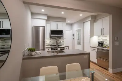 a kitchen with white cabinets and a glass table at 645 Fresh Modern Condo Inside Resort Gates - Free Wifi - Walk to Spa in Encinitas