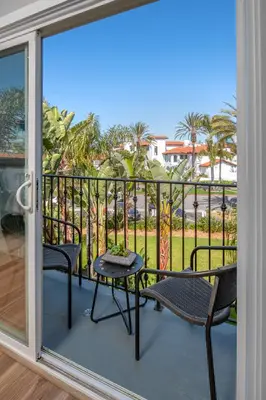 a patio with two chairs and a table on a balcony at 645 Fresh Modern Condo Inside Resort Gates - Free Wifi - Walk to Spa in Encinitas