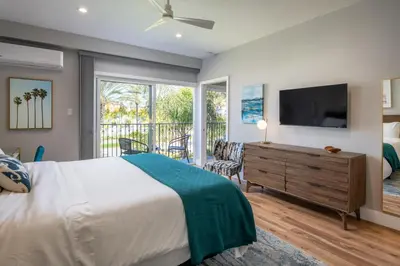 a bedroom with a bed and a tv and a balcony at 645 Fresh Modern Condo Inside Resort Gates - Free Wifi - Walk to Spa in Encinitas
