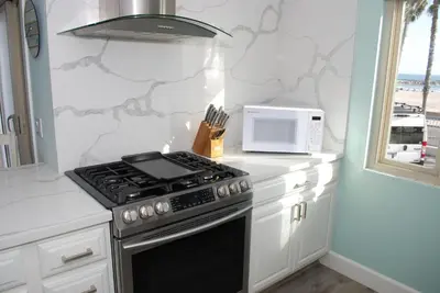 a kitchen with a stove and a microwave at 207A Fresh, Renovated and Steps from the Beach in Oceanside