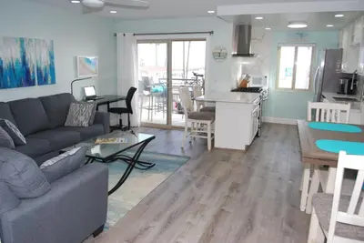a living room and kitchen with a couch and a table at 207A Fresh, Renovated and Steps from the Beach in Oceanside