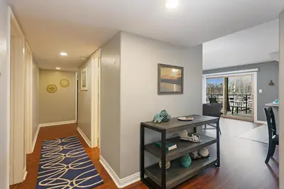 a living room with a table and a hallway at 210B Harbor Views Short Stroll to Beach, Large Balcony, Walk to Dining Shops in Oceanside