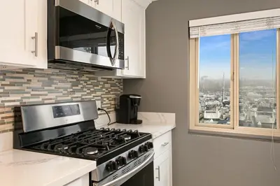a kitchen with a stove and a microwave at 210B Harbor Views Short Stroll to Beach, Large Balcony, Walk to Dining Shops in Oceanside