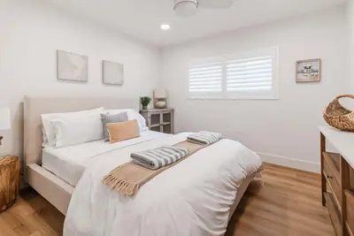 a white bedroom with a large bed with a window at 211A Freshly Renovated Steps from the Sand at the Beach Oceanside in Oceanside