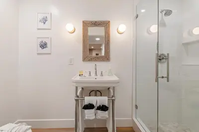 a white bathroom with a sink and a shower at 211A Freshly Renovated Steps from the Sand at the Beach Oceanside in Oceanside