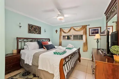 a bedroom with a bed and a dresser and a television at 211B - Harbor, Seals, Birds, Night Lights, Steps to the Sand! in Oceanside