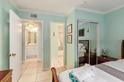 a bedroom with a bed and a bathroom at 211B - Harbor, Seals, Birds, Night Lights, Steps to the Sand! in Oceanside