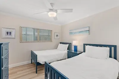 a bedroom with two beds and a ceiling fan at 211B - Harbor, Seals, Birds, Night Lights, Steps to the Sand! in Oceanside