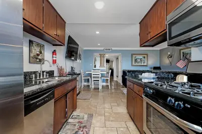 a kitchen with a sink and a stove top oven at 213A - Take a Beach Break at Marina Del Mar - Beach & Ocean Views in Oceanside