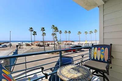 a balcony with a table and a chair and the beach at 215A - Beautiful Sunsets, Beach View, Free Wifi in Oceanside