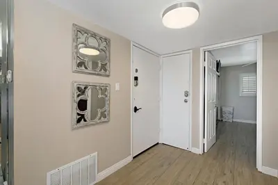 a hallway with white walls and wood floors and a door at 215A - Beautiful Sunsets, Beach View, Free Wifi in Oceanside